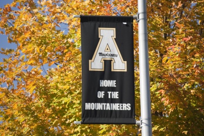 Appalachian State University light pole banner in front of fall leaves