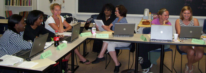 students doing group work with laptops at a table